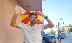 Aşırı sıcaklar nedeniyle kafasına taktığı şemsiye ile geziyor